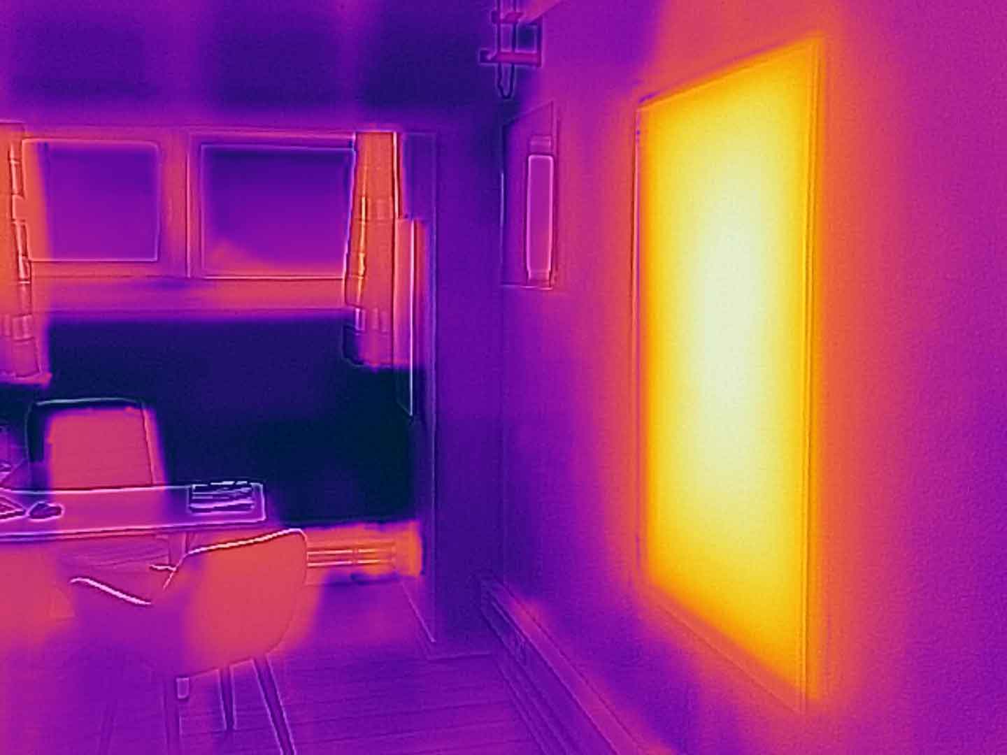 Infraroodverwarming - Een infraroodpaneel aan de wand geeft stralingswarmte Infraroodverwarming - Een infraroodpaneel aan de wand geeft stralingswarmte